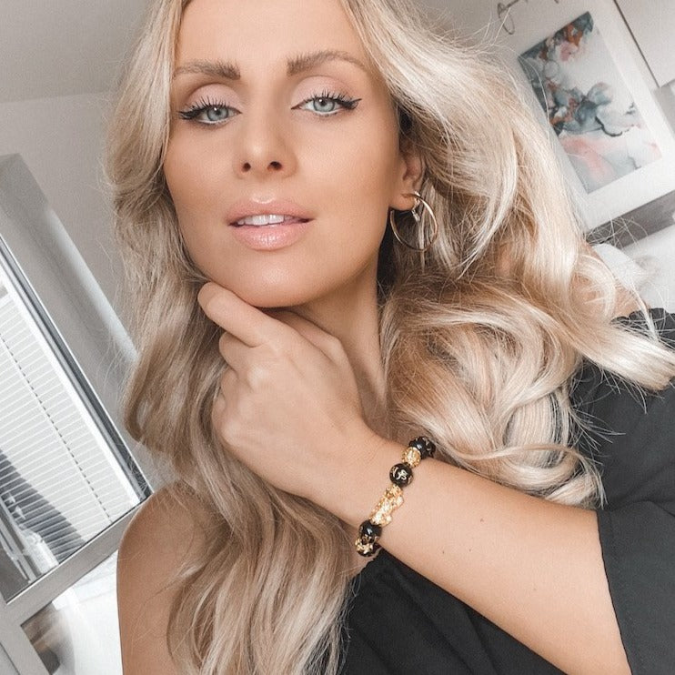 rau trägt schwarzes WOHLSTAND-Achat-Armband mit Pixiu-Symbol